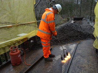 The water below the ballast runs to the lower end of the bridge. Sealing the concrete deck will ensure it will not penetrate the concrete and reach the ironwork of the bridge below